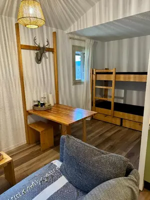 a living room with a table and a bunk bed at Les Airelles 402 in Arâches-la-Frasse