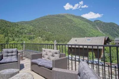 a balcony with chairs and a view of a mountain at La Terrasse- Panoramique- Familial-Près des pistes in Les Houches