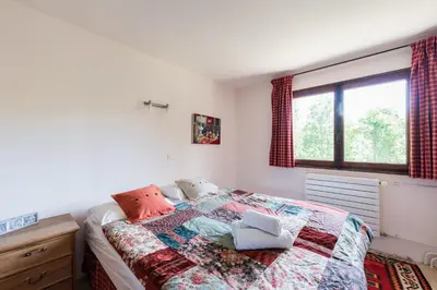 a bedroom with a bed with a quilt on it at Chalet l'Arba - Ecrin à la croisée des stations in Cordon