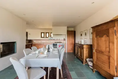 a kitchen with a table with white chairs and a kitchen at Chalet l'Arba - Ecrin à la croisée des stations in Cordon