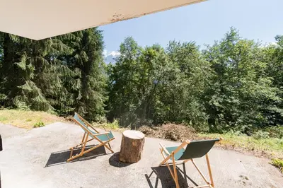 two chairs and a table and a tree stump at Chalet l'Arba - Ecrin à la croisée des stations in Cordon