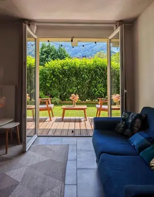 a living room with a blue couch and a patio at Appartement avec jardin in Saint-Gervais-les-Bains