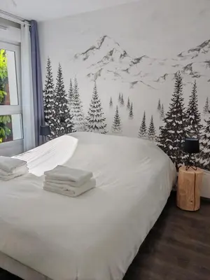 a bedroom with a snow covered mountain mural on the wall at Appartement avec jardin in Saint-Gervais-les-Bains