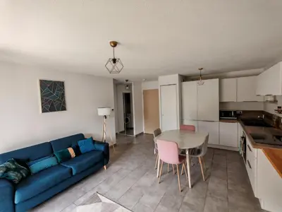 a living room with a blue couch and a table at Appartement avec jardin in Saint-Gervais-les-Bains