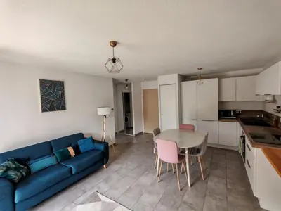 a living room with a blue couch and a table at Appartement avec jardin in Saint-Gervais-les-Bains