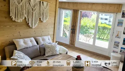 a living room with a couch and a large window at Joli studio avec terrasse in Sallanches