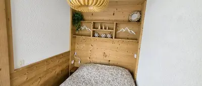 a small room with a bed and a chandelier at Joli studio avec terrasse in Sallanches