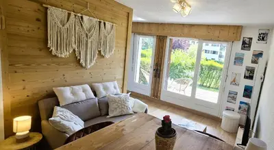 a living room with a couch and a table at Joli studio avec terrasse in Sallanches
