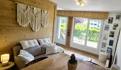 a living room with a couch and a table at Joli studio avec terrasse in Sallanches