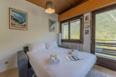 a bedroom with a white bed and a large window at Le Refuge Du Bouchet - Happy Rentals in Chamonix-Mont-Blanc