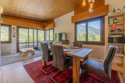 a dining room with a table and chairs and mountains at Le Refuge Du Bouchet - Happy Rentals in Chamonix-Mont-Blanc