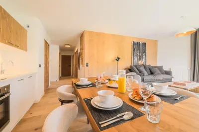a dining room and living room with a table and chairs at TERRESENS - Les Sources de Canopée in Saint-Gervais-les-Bains