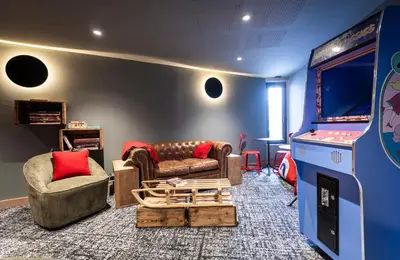 a living room with two couches and a video game at TERRESENS - Les Sources de Canopée in Saint-Gervais-les-Bains