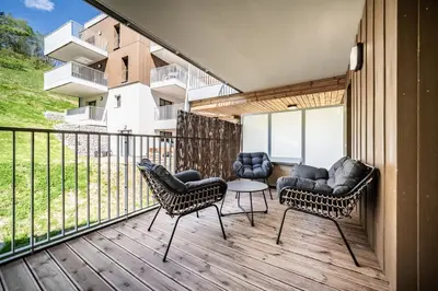 a balcony with two chairs and a table on it at Apartment Mathilde Les Houches - by EMERALD STAY in Les Houches
