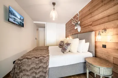 a bedroom with a bed with a wooden wall at Apartment Mathilde Les Houches - by EMERALD STAY in Les Houches
