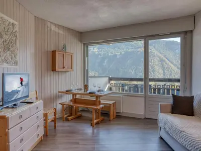 a living room with a table and a large window at Studio rénové proche des remontées mécaniques avec Wifi - FR-1-663-26 in Saint-Gervais-les-Bains