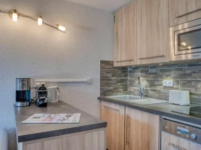 a kitchen with a large bed in a room at Studio rénové proche des remontées mécaniques avec Wifi - FR-1-663-26 in Saint-Gervais-les-Bains