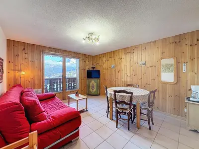 a living room with a red couch and a table at Appartement proche village, accès ski bus, vue Mont Blanc - FR-1-560-163 in Combloux