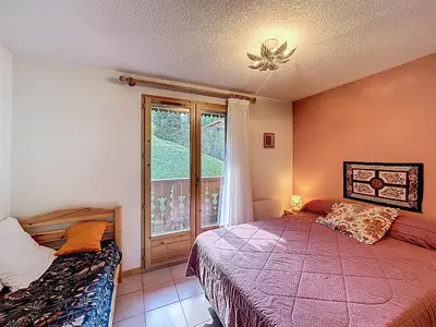 a bedroom with two beds and a window at Appartement proche village, accès ski bus, vue Mont Blanc - FR-1-560-163 in Combloux