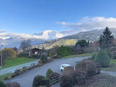 a car parked on a road with mountains in the background at Appartement proche village, accès ski bus, vue Mont Blanc - FR-1-560-163 in Combloux