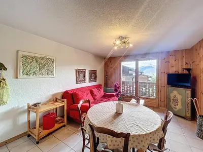 a living room with a table and a red couch at Appartement proche village, accès ski bus, vue Mont Blanc - FR-1-560-163 in Combloux