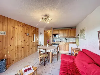 a living room with a red couch and a table at Appartement proche village, accès ski bus, vue Mont Blanc - FR-1-560-163 in Combloux