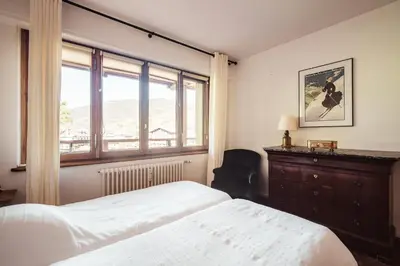 a bedroom with a bed and a large window at Le Central - In the heart of Megève in Megève