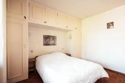a bedroom with a white bed and white cabinets at Le Central - In the heart of Megève in Megève