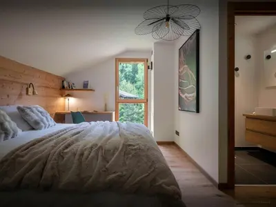 a bedroom with a bed and a chair and a pillow at Chalet Ormiages - OVO Network in Saint-Gervais-les-Bains