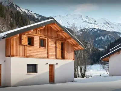 a village covered in snow with mountains in the background at Chalet Ormiages - OVO Network in Saint-Gervais-les-Bains
