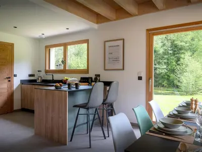 a kitchen with wooden cabinets and a dining room at Chalet Ormiages - OVO Network in Saint-Gervais-les-Bains