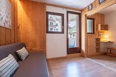 a living room with a couch and a window at Joli appartement Aiguille du Midi in Chamonix-Mont-Blanc
