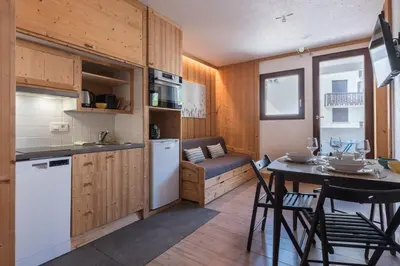 a small room with a table and a bedroom at Joli appartement Aiguille du Midi in Chamonix-Mont-Blanc