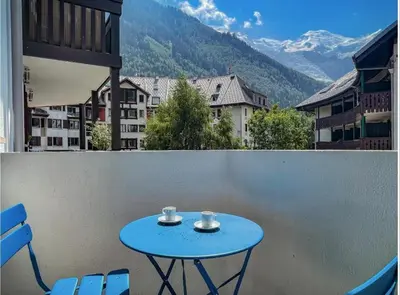a kitchen with a table and a clock on the wall at Joli appartement Aiguille du Midi in Chamonix-Mont-Blanc