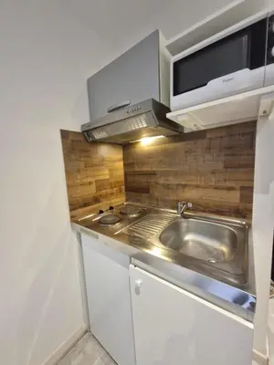 a kitchen with a sink and a microwave at Studio with WiFi at the foot of the slopes in Megève