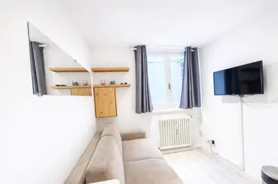 a living room with a couch and a flat screen tv at Studio with WiFi at the foot of the slopes in Megève