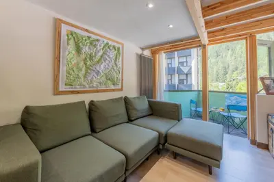 a kitchen and dining room with a table and a vase at Résidence Grand Roc - Bruyères 221 - Happy Rentals in Chamonix-Mont-Blanc