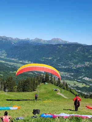 a person flying a parachute in a field at SamoensDt in Samoëns