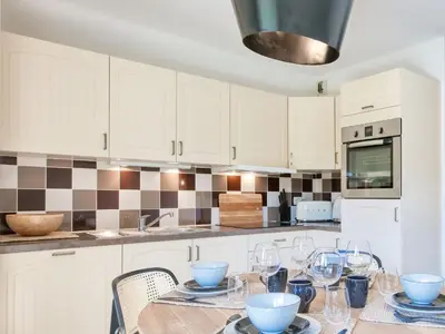 a living room with a dining table and a large window at Saint-Gervais : Appartement rénové 2 ch, jardin, WiFi & parking - FR-1-663-34 in Saint-Gervais-les-Bains