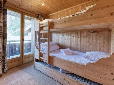 a bedroom with a large bed and a tv at Chalet familial à Saint-Gervais, 6 chambres, 12 pers, WiFi, parking - FR-1-663-27 in Saint-Gervais-les-Bains