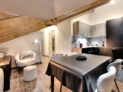 a kitchen with black cabinets and a red appliance at Appartement cosy avec cheminée et parking, proche centre - FR-1-663-38 in Saint-Gervais-les-Bains