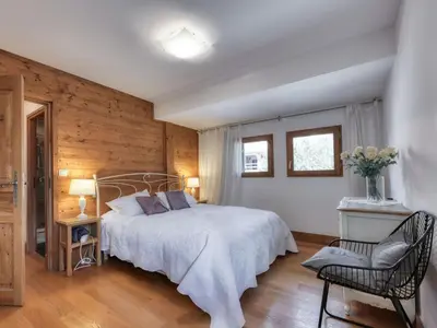 a bedroom with a large bed and a chair at Appartement duplex avec vue montagne, 8 pers, parking, Wi-Fi - FR-1-663-36 in Saint-Gervais-les-Bains