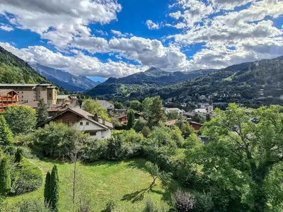 a balcony with a table and a view of mountains at Appartement duplex avec vue montagne, 8 pers, parking, Wi-Fi - FR-1-663-36 in Saint-Gervais-les-Bains
