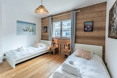 a bedroom with two beds and a window at Alpin chic au cœur de Chamonix in Chamonix-Mont-Blanc
