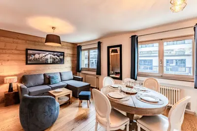 a living room with a table and a couch at Alpin chic au cœur de Chamonix in Chamonix-Mont-Blanc
