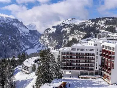 a large building in the snow with mountains at Appartement spacieux Flain - Ski aux pieds et parking - FR-1-425-235 in Arâches-la-Frasse