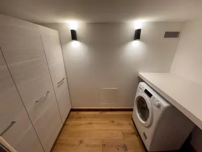 a laundry room with a washing machine and two lights at Chalet La Frasse in Chamonix-Mont-Blanc
