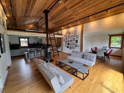 a living room with couches and a table and a kitchen at Chalet La Frasse in Chamonix-Mont-Blanc