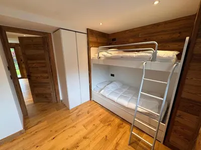a room with two bunk beds and a wooden floor at Chalet La Frasse in Chamonix-Mont-Blanc