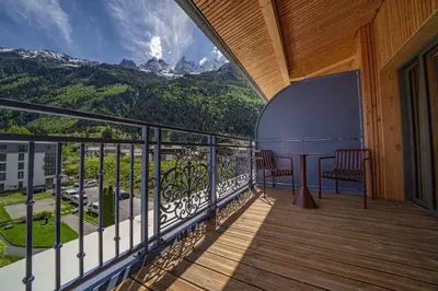 a balcony with two chairs and a view of a mountain at Paradisa Penthouse in Chamonix-Mont-Blanc